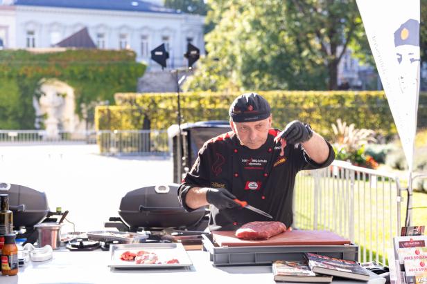 Der Grillmeister schneidet das Fleisch zurecht