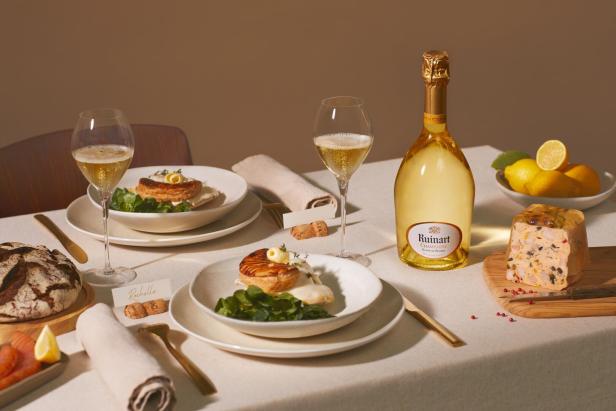 Eine gedeckte Tafel mit Essen, Champagner-Gläsern und einer Champagnerflasche