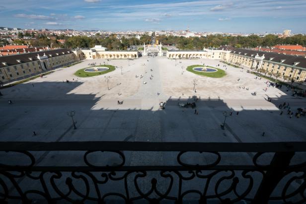 Das Schloss Schönbrunn wirft einen Schatten auf den Ehrenhof. Blick von ganz oben auf die Szenerie.