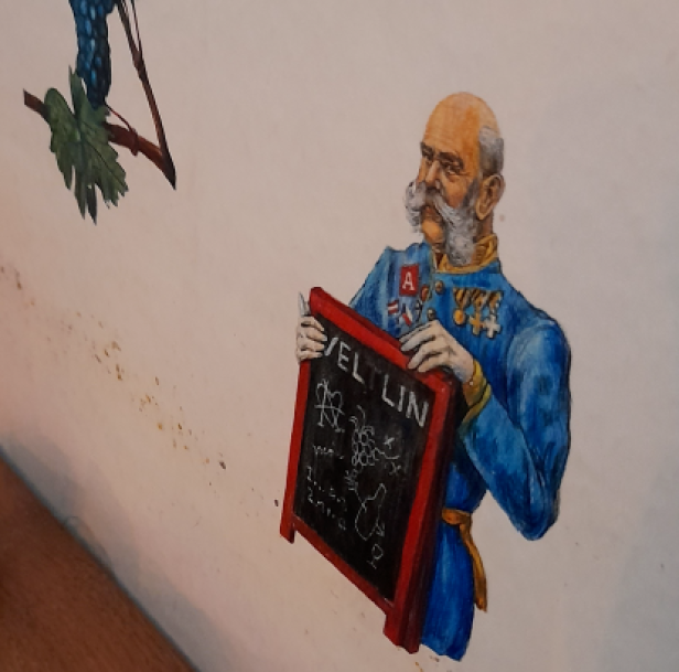 Kaiser Franz Joseph ist auf eine Wand gemalt - er hat eine Tafel in der Hand, auf der Veltlin steht