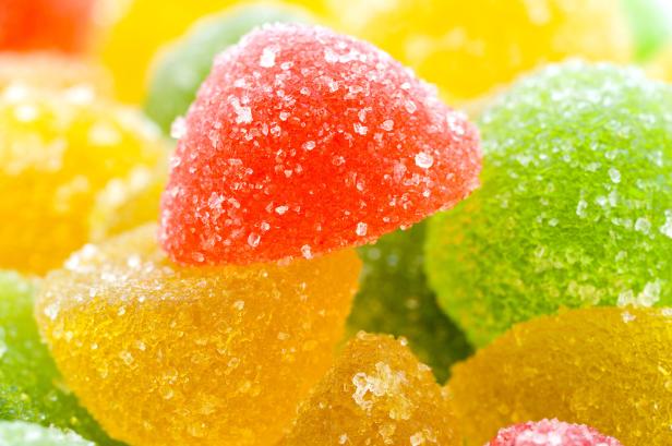 Bunte, zuckerüberzogene Geleebonbons in Rot, Gelb und Grün liegen dicht beieinander.