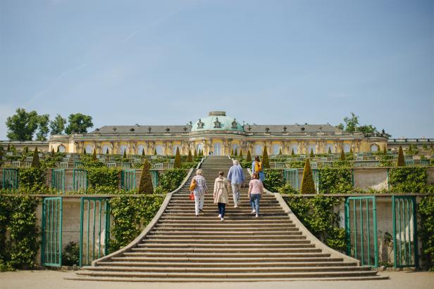 Eine Familie geht die Treppen zum Palast hinauf und genießt den majestätischen Anblick des Gebäudes.