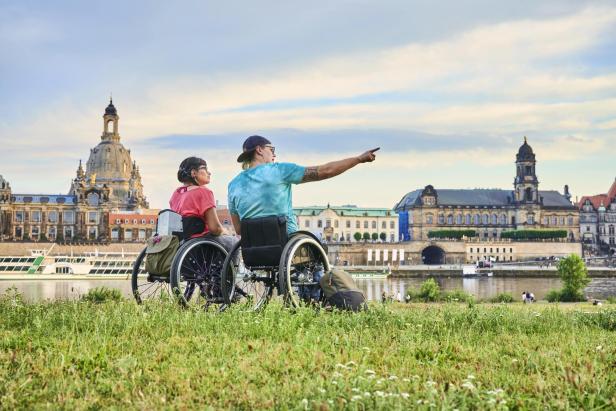 Ein Paar in Dresden im Rollstuhl am Elbufer.