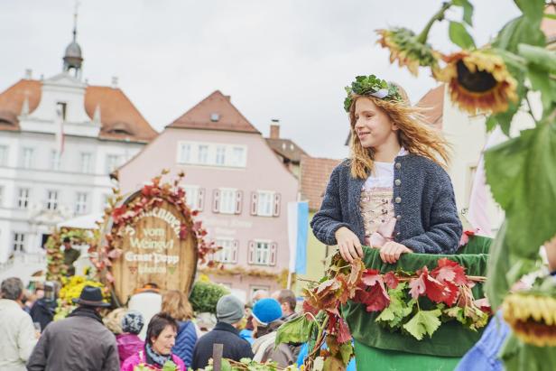 Ein Mädchen auf einem Stadtfest mit Blumen im Haar.