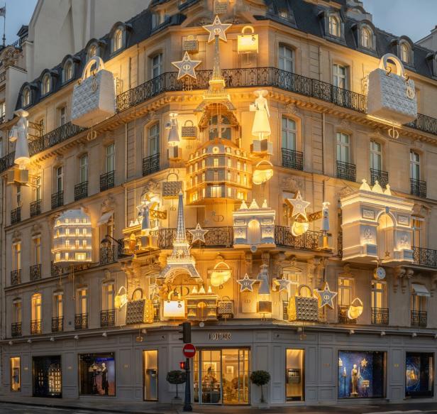 Auf der Hausfassaden von Dior in Paris hängen neben Sternen der Eiffelturm oder der Triumphbogen wie ein großer Weihnachtsschmuck 