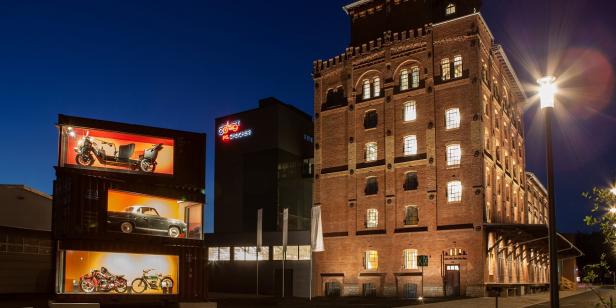 Ein altes, mehrstöckiges Gebäude bei Nacht, eine Straßenlaterne ist davor angeschaltet. 