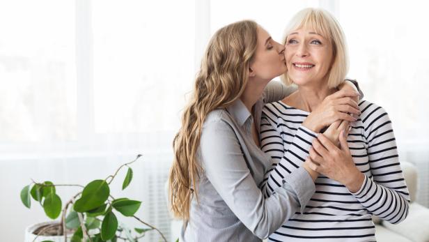 Daughter kissing her mature mother on the cheek