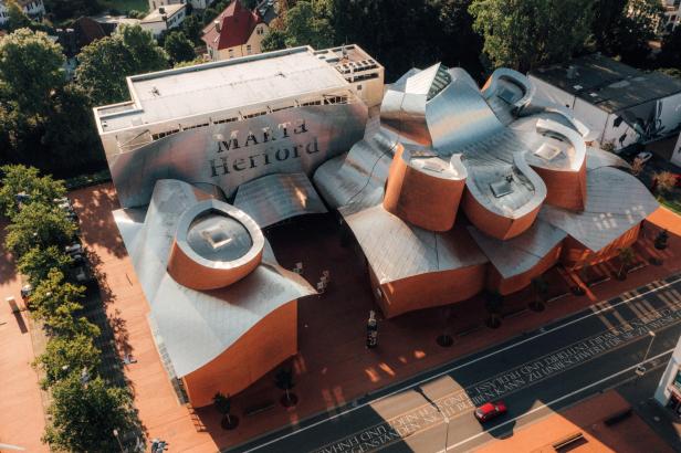 Ein oranges, gewölbenes Gebäude von oben 