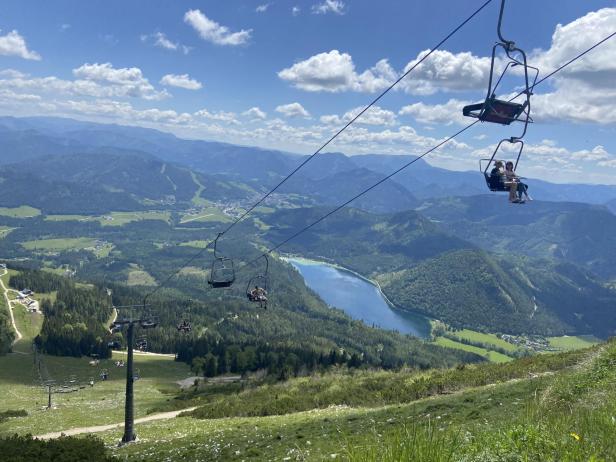 Eine Sessellift mit zwei Personen, die entspannt sitzen und die Aussicht genießen.