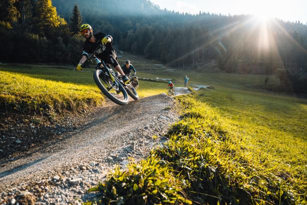 Ein Mountainbike-Fahrer mit Helm hüpft über Kamelbuckeln.