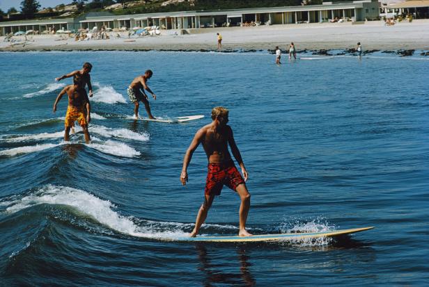 Mehrere Surfer auf einer kleinen Welle