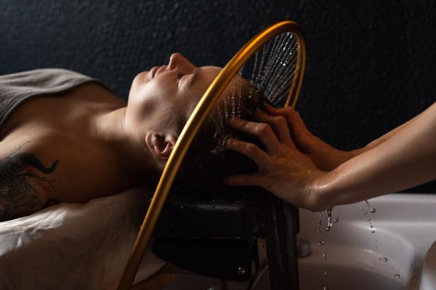 Masseur doing massage the head and hair for an woman in spa salon.