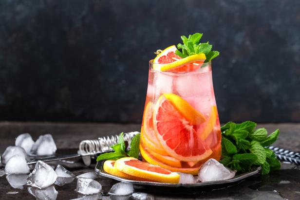 Grapefruit and fresh mint cocktail with juice, cold summer citrus refreshing drink or beverage with ice