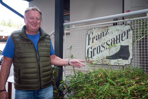Franz Grossauer steht vor seinem Namensschild