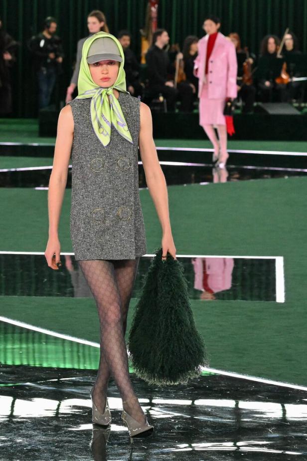 Herbst-Winter-Kollektion 2025 von Gucci: Ein Model trägt ein Seidentuch über einer Kappe zum Minikleid.