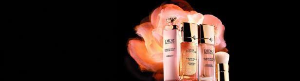 Drei Dior Prestige Hautpflegeprodukte vor einer verschwommenen Rose auf schwarzem Hintergrund.