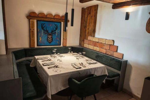 Ein gedeckter Tisch in einem Restaurant mit einer Hirsch-Grafik an der Wand.