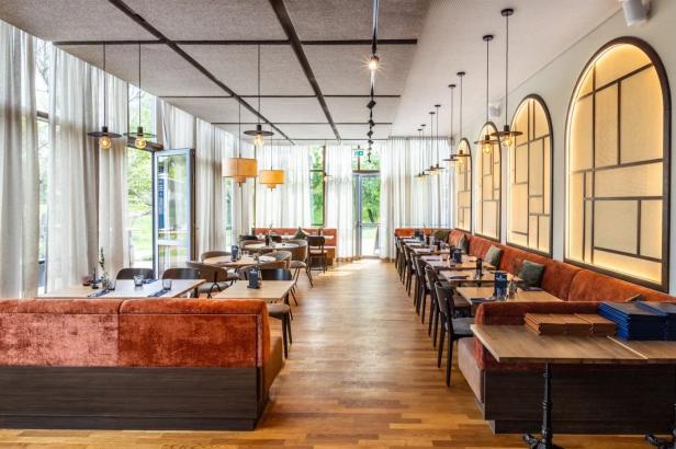 Ein elegantes Restaurant mit Tischen und Stühlen, bereit für Gäste.