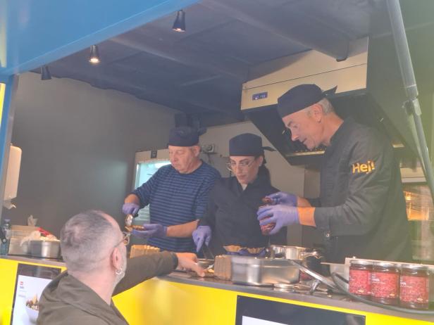 Ein Food-Truck mit drei Köchen, die Ikeas neue Speise anrichten.