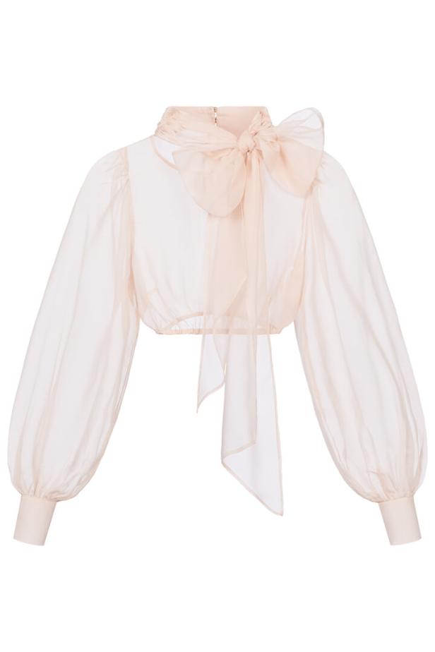 Eine hellrosa, transparente Bluse mit langen Ärmeln und einer großen Schleife am Kragen.