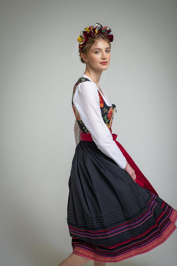 Eine junge Frau in Tracht mit Dirndl, Bluse und traditionellem Kopfschmuck.