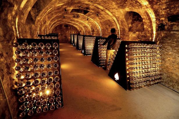Champagnerflaschenregale stehen in einem Gewölbekeller.