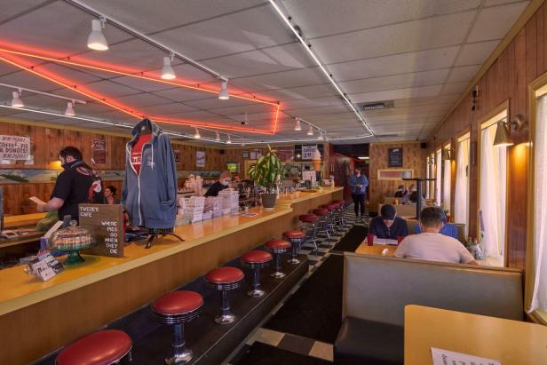 Innenansicht von Twede's Cafe mit Gästen und roter Neonbeleuchtung.