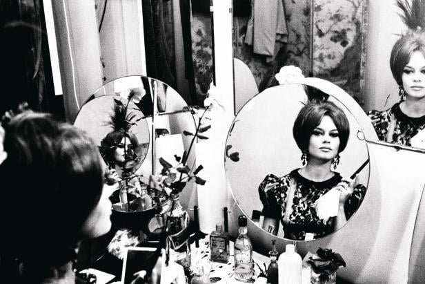 Brigitte Bardot vor einem Spiegel beim Schminken.