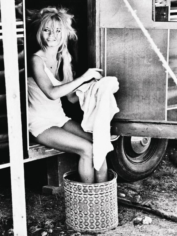Brigitte Bardot sitzt mit ihren Füßen in einem Eimer und hält ein Handtuch.