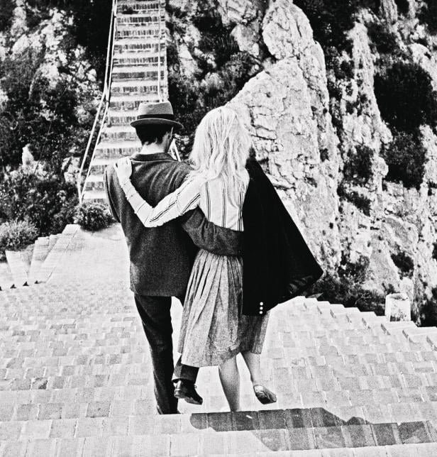 Brigitte Bardot und ein Mann umarmen sich auf einer Treppe in der Nähe der Villa Malaparte.