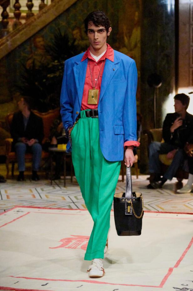 Mann in grüner Hose, rotem Hemd und blauem Sakko in Versace Show