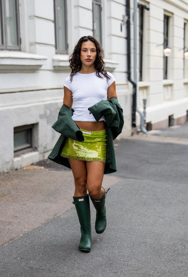 Bei der Oslo Fashion Week posierte ein Model mit dunkelgrünen Hunter-Stiefeln mit einer farblich abgestimmten Jacke und knallgrünem Mini-Rock.