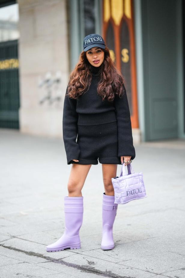 Model posiert mit lila Gummistiefeln von der Marke Patou