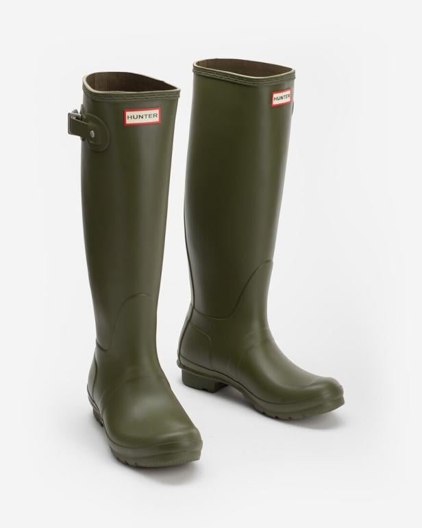 Alltagstauglich und robust: Dunkelgrüne, kniehohe Gummistiefel mit Schnalle von der britischen Marke Hunter.