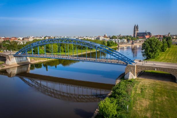 Luftbild von Magdeburg an der Elbe mit einer Brücke im Vordergrund.