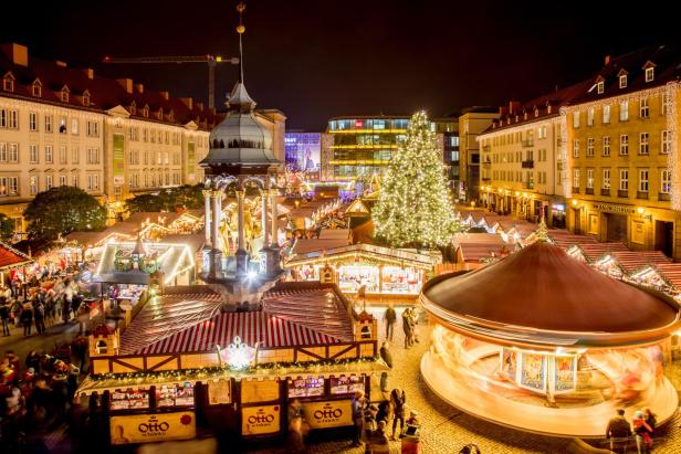 Weihnachtsmarkt in Magdeburg, Deutschland, voller Lichter, Stände und Besucher, die die festliche Atmosphäre genießen.