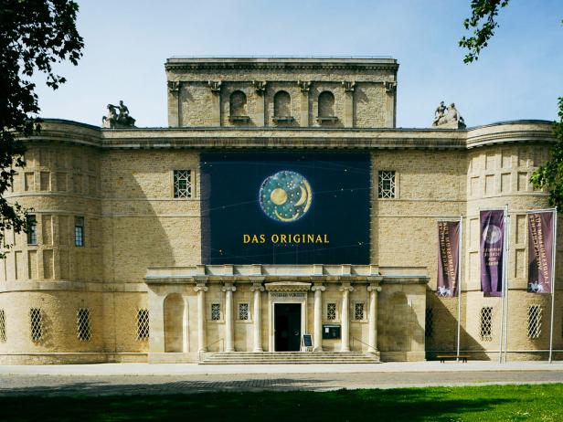 Ein großes Gebäude mit der Himmelsscheibe von Nebra an der Fassade.