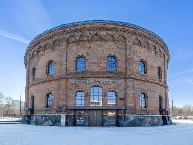 Ziegelsteinbau in runder Form mit Fenstern, der eine einzigartige architektonische Gestaltung zeigt.