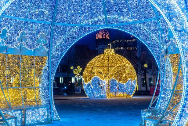 Ein blauer und weißer Torbogen mit Lichtern, der festliche Stimmung vermittelt.