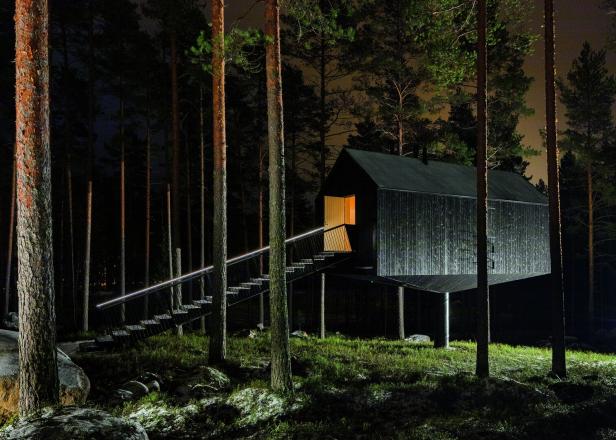 Eine reduzierte Holzhütte, die nur auf einem Pflock zu stehen scheint.