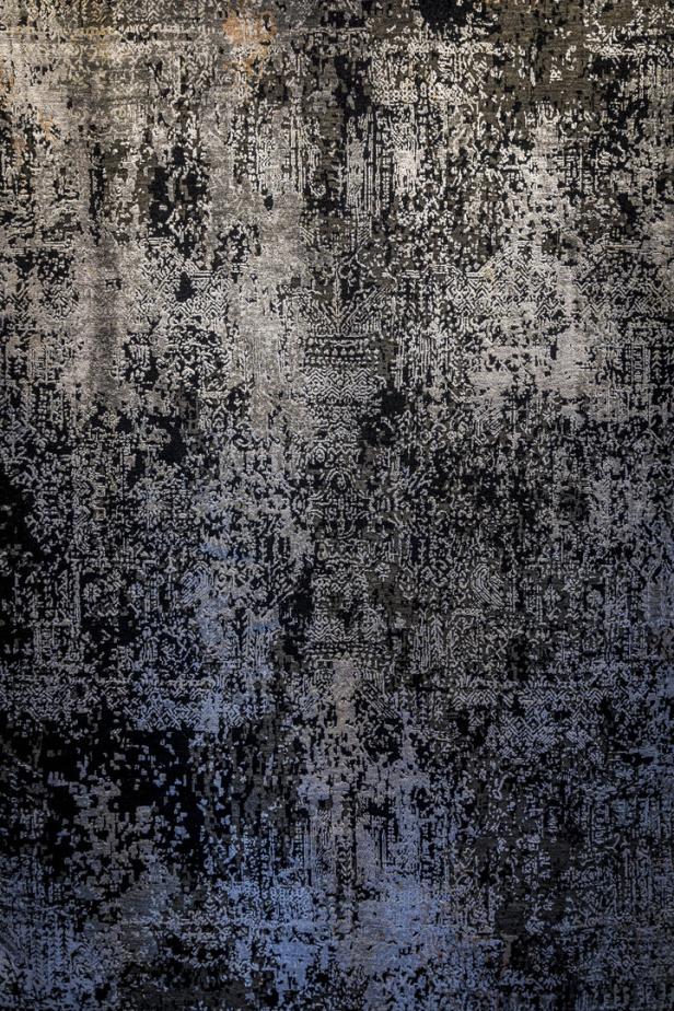 Ein klassisches Teppichmuster, das sich unter einer dunklen Schicht verbirgt