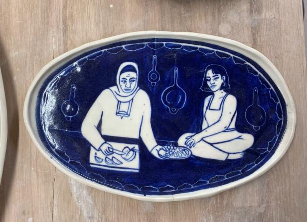 Keramikteller mit Motiv zwei Frauen (eine davon mit Kopfschleier) beim Essen von Obst von Rama Duwaji