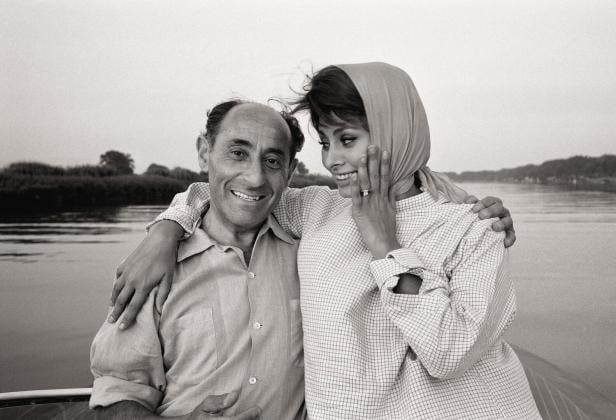 Sophia Loren hat den Arm um Eisies Schulter gelegt, sie sieht ihn an. Er lächelt.