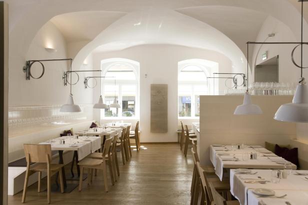 Die Innenansicht von Plachuttas Gasthaus zur Oper  - ein helles, modern eingerichtetes Gasthaus mit Holzmöbleln und weiß gedeckten Tischen