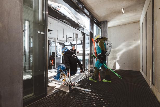 Monoskifahrer steigt in die Gondel ein