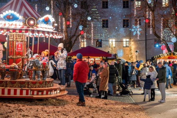 Winterlicher Markt mit viel Lichtern und einem Karussell.