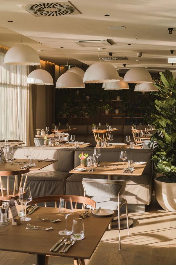 Restaurant in einem Hotel mit vielen Lampen und Tischen aus Holz