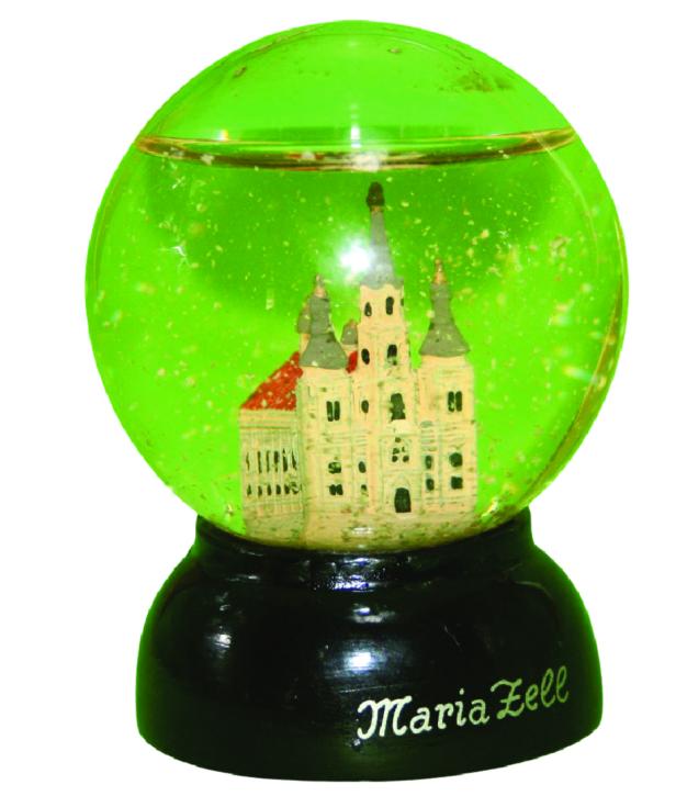 Eine Schneekugel mit einer Miniatur-Kirche und der Aufschrift "Maria Zell" auf dem schwarzen Sockel.