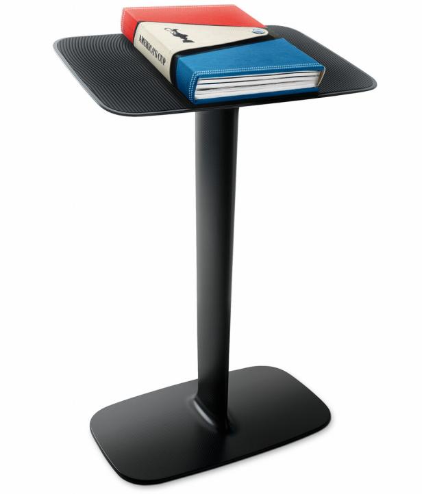 Schwarzer Stehtisch mit rechteckiger Platte, darauf liegt der Amcerica's Cup-bildband mit Ledereinband.