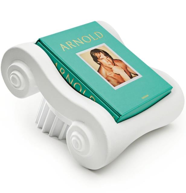 Ein Buch mit dem Titel "Arnold" liegt in einer weißen, dekorativen Halterung.